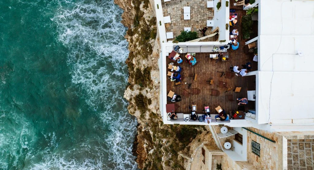 Outdoor dining table overlooking the ocean in a coastal cliffside village