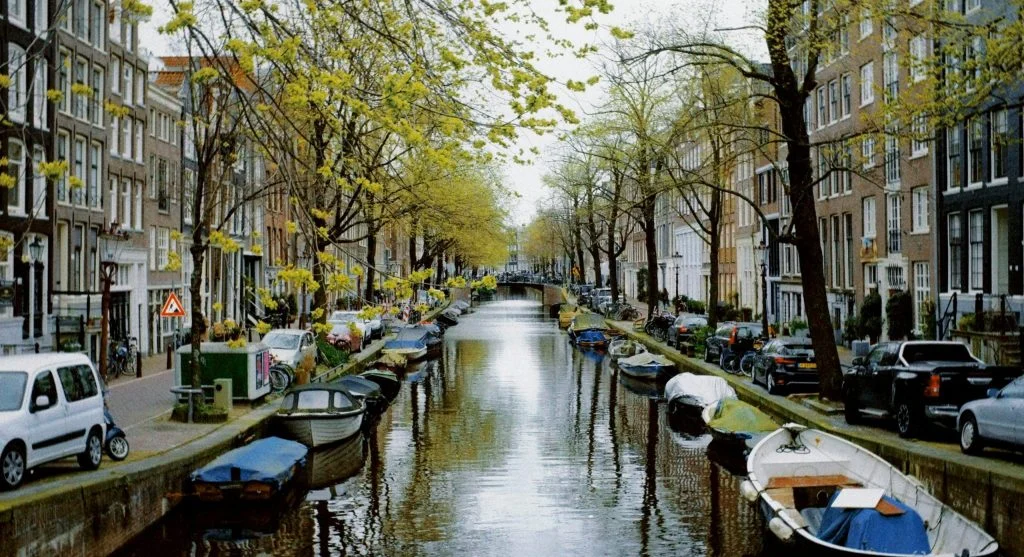 Colorful historic buildings along a peaceful canal during seasonal travel