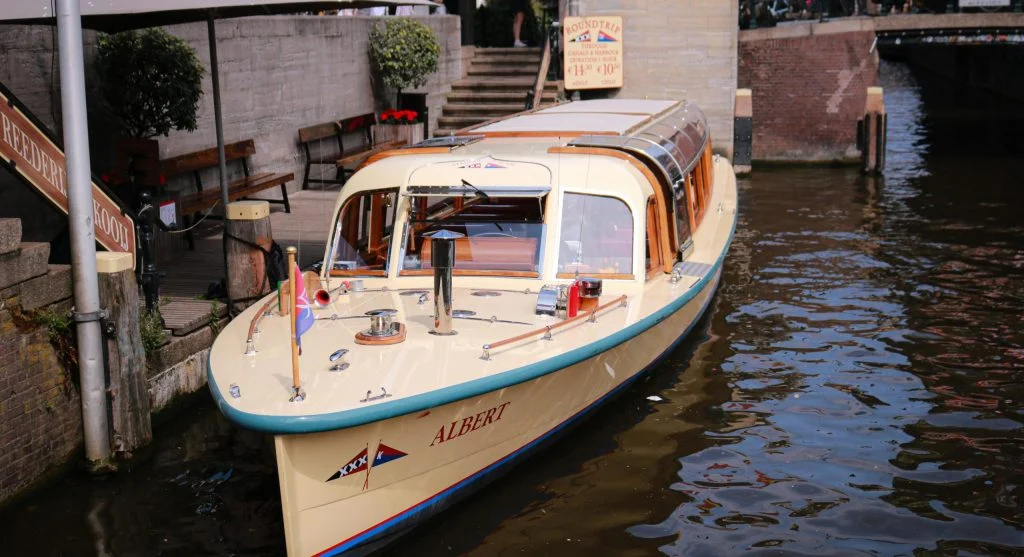 Small luxury boat cruising on a serene European canal