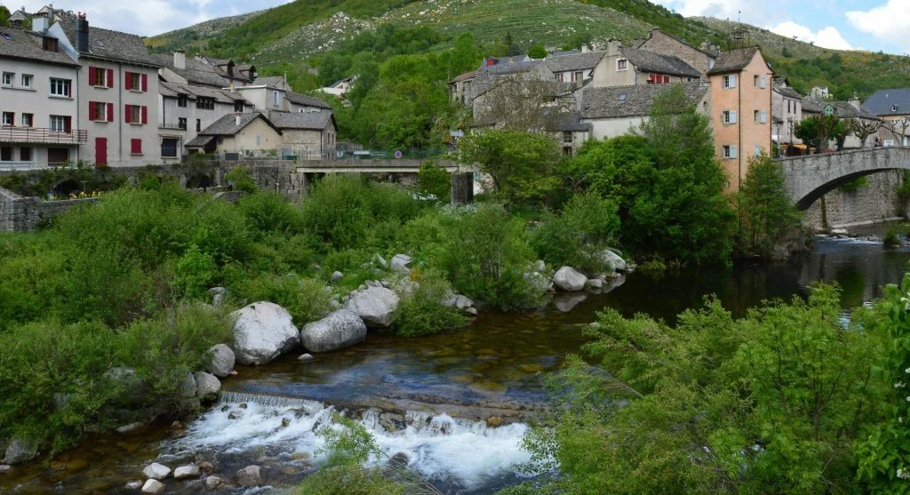 Cyclist riding along a scenic waterway in the European countryside