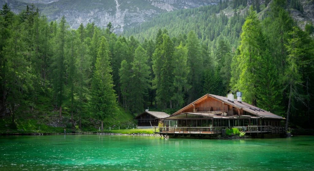 Eco lodges floating on a lake surrounded by lush greenery and mountains