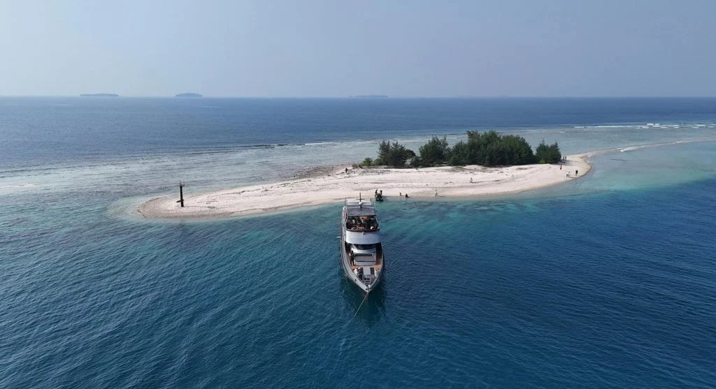 Luxury yacht sailing near secluded coastline