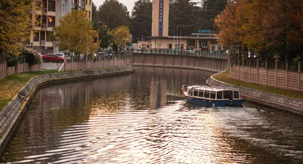 Serene autumn canal scene with a boat cruise