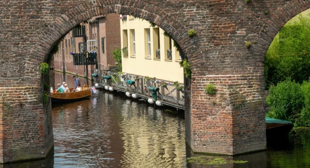 Luxury boat sailing through a picturesque Dutch canal town