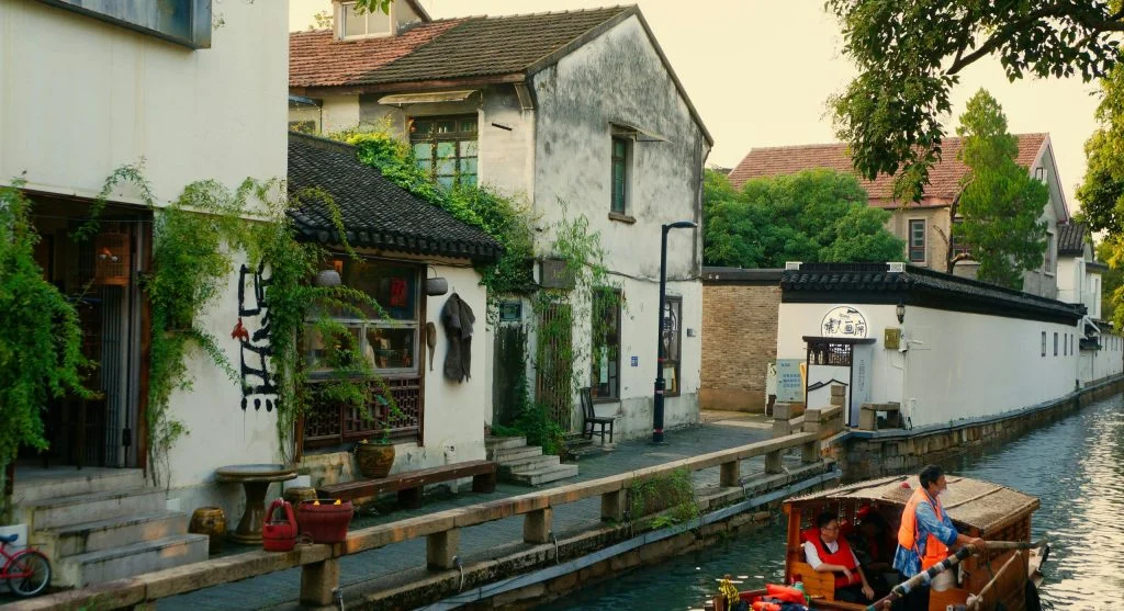 Peaceful canal scene with boats and surrounding landscape
