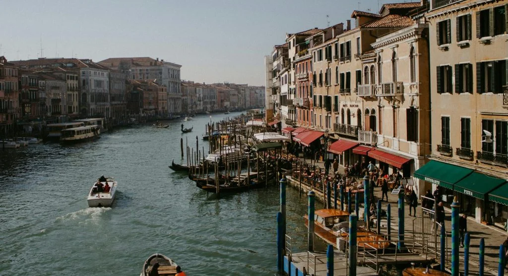Scenic floating breakfast setup with pastries and coffee beside a serene European canal