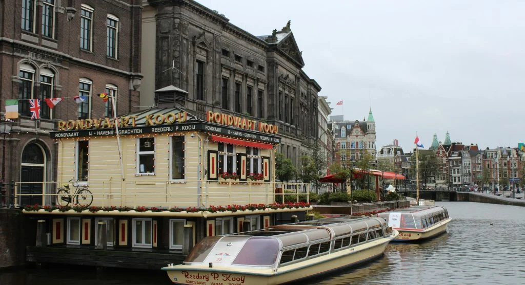People dining at a waterfront restaurant in a scenic Dutch canal town