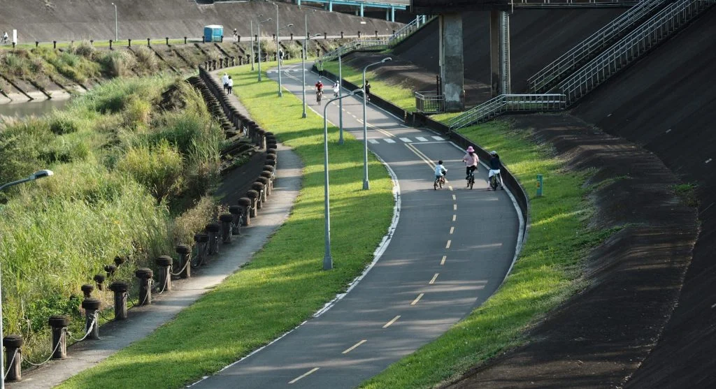 Person cycling along a waterway with a camera