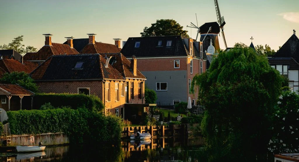 People biking and walking near a Dutch canal town